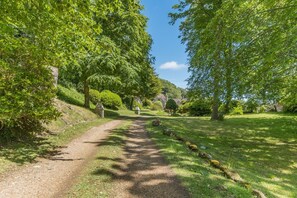 A pathway leading through a lush green landscape with trees and a clear sky. - 2 Bed in Niton Undercliff (oc-60945) (Niton)