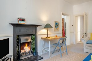A living room with a fireplace, a desk, a chair, and a sofa. - 2 Bed in Niton Undercliff (oc-60945) (Niton)