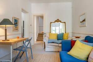 A living room with a sofa, a table, a lamp, and a mirror. - 2 Bed in Niton Undercliff (oc-60945) (Niton)