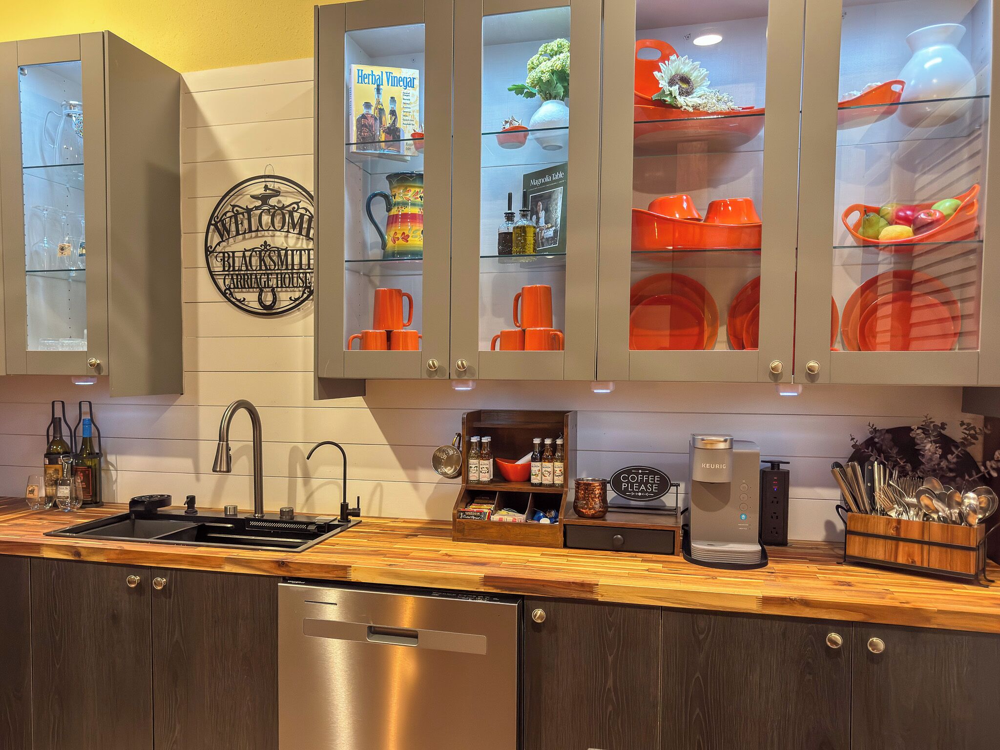 A kitchen with a built-in dishwasher, a coffee machine, and a sign that says 'Coffee Please.'