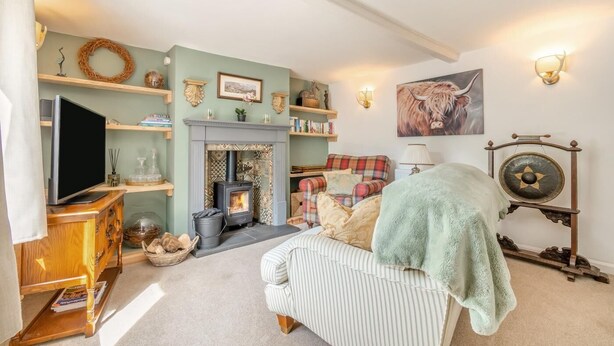 A cozy living room with a fireplace, a television, and a comfortable sofa. - 2 Bed in Partney (oc-v44757) (Partney)