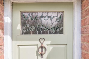 A door with a window displaying 'Victory Cottage' in green letters. - 2 Bed in Partney (oc-v44757) (Partney)
