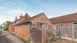 A brick house with a wooden gate and a paved driveway. - 2 Bed in Partney (oc-v44757) (Partney)