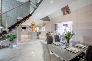 Un interno moderno con zona pranzo, cucina e scalinata.