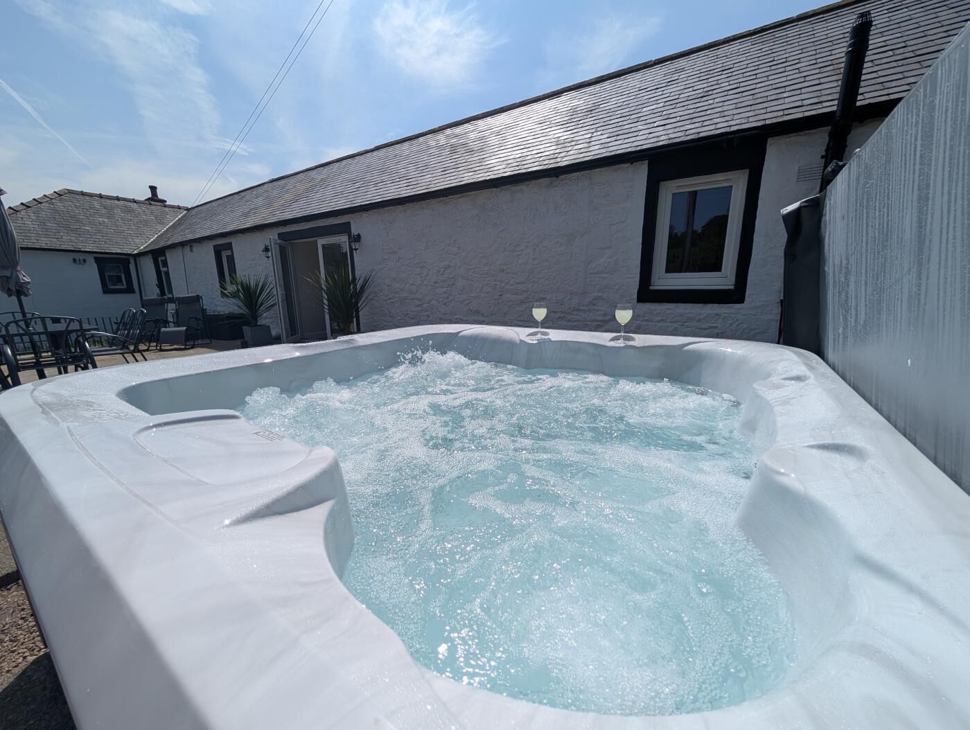 A hot tub in a backyard with a house in the background.