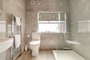 A modern bathroom with a bathtub, toilet, and vanity. - 5 Bed in Pocklington (oc-m45222) (Pocklington)