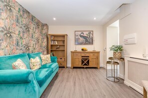 A living room with a teal sofa, wooden bookshelf, and a framed picture on the wall. - 5 Bed in Pocklington (oc-m45222) (Pocklington)