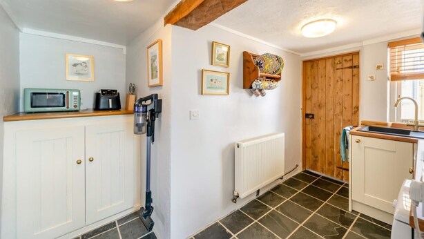 A compact kitchen with white cabinets, a microwave, a kettle, and a radiator. - 1 Bed in Appledore (oc-l45327) (Appledore)