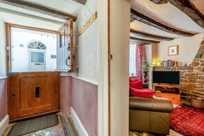 Ein gemütliches Wohnzimmer mit Kamin, Fernseher und einem roten Sofa.