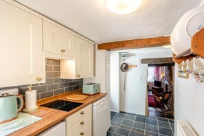 Eine Küche mit weißen Schränken, einer Holz Arbeitsplatte, einem Toaster und einem Herd.