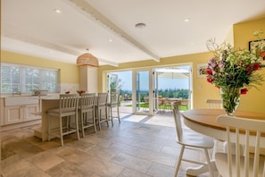 A spacious kitchen with a dining area, large windows, and a view of the outdoors. - 6 Bed in Herons Ghyll (oc-t44940) (Heron's Ghyll)
