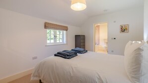 Une chambre à coucher avec un lit, une fenêtre donnant sur un beau paysage, une armoire et une porte menant à la salle de bain.