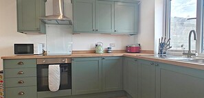 A kitchen with a microwave, kettle, toaster, and oven. - 3 Bed in Pendeen (oc-g33305) (Pendeen)