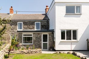 A two-story house with a stone facade and a white extension. - 3 Bed in Pendeen (oc-g33305) (Pendeen)