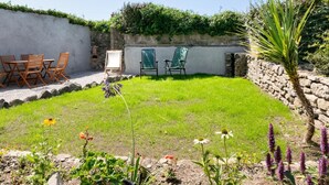 A garden with a lawn, chairs, and a stone wall. - 3 Bed in Pendeen (oc-g33305) (Pendeen)