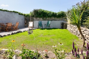 A garden with a lawn, chairs, and a stone wall. - 3 Bed in Pendeen (oc-g33305) (Pendeen)