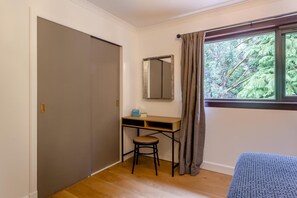 A room with a wooden desk, a chair, a window with curtains, and a door. - 3 Bed in Lairg (oc-r44959) (Little Assynt)