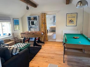A cozy living room with a foosball table, a pool table, and a bookshelf. - 3 Bed in Overton (oc-b45279) (Overton)