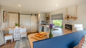 A modern kitchen with a dining area, a large window, and a view of greenery outside. - 2 Bed in Overton (oc-k45280) (Overton)