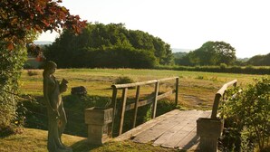 A statue of a woman in a field with a wooden bridge and a stone structure. - 2 Bed in Overton (oc-k45280) (Overton)