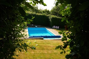A rectangular swimming pool with a surrounding deck, surrounded by a well-maintained hedge. - 2 Bed in Overton (oc-k45280) (Overton)