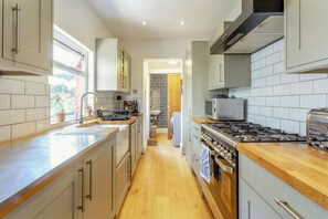 Una cocina moderna con una isla central, electrodomésticos de acero inoxidable y vista al área de comedor.