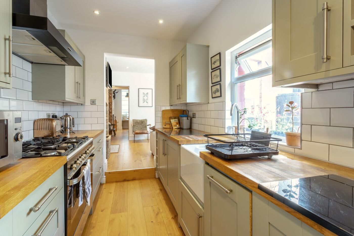 A modern kitchen with a central island, stainless steel appliances, and a view to the outside.