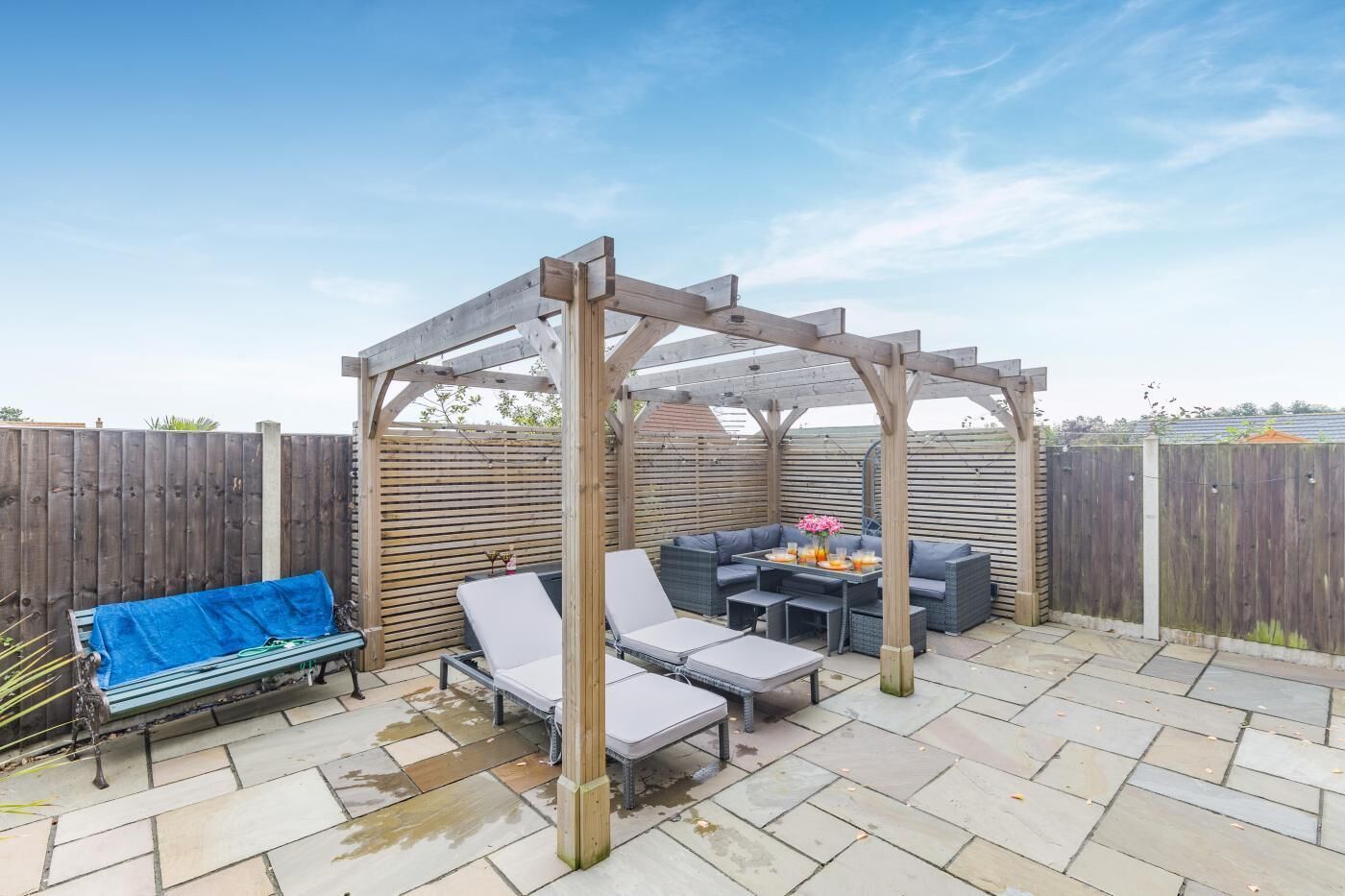 Ein überdachter Patio-Bereich mit einer Holzhütte, Sitzgelegenheiten im Freien und einem Tisch mit Getränken.