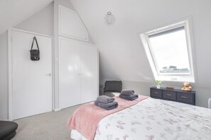 A bedroom with a bed, a wardrobe, a window, and a teddy bear on a dresser. - 3 Bed in Sheringham (oc-s44832) (Sheringham)