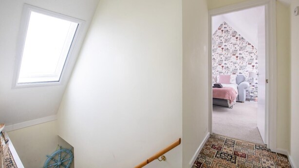 A room with a bed, a window, and a door leading to another room with a patterned wall. - 3 Bed in Sheringham (oc-s44832) (Sheringham)