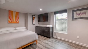Un dormitorio con cama, cómoda y obras de arte en las paredes.