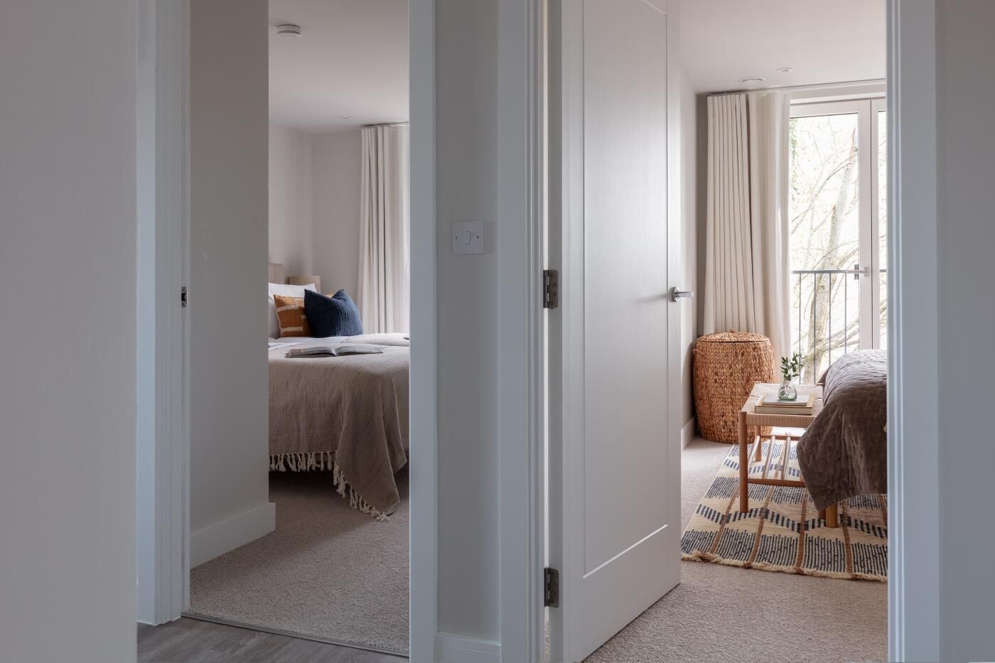 Een hotelkamer met een bed, nachtkastje, raam met gordijnen en uitzicht op de omgeving.