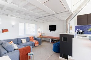 Ett modernt vardagsrum med en soffa, en tv och en öppen spis.