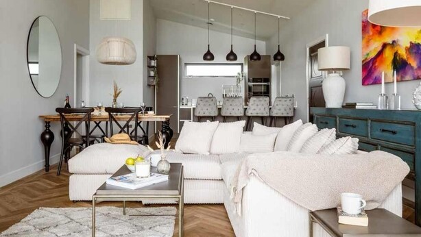 En moderne stue med sofa, sofabord og spiseplads.