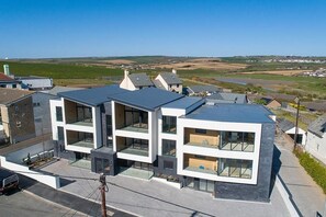 A modern two-story residential building with large windows and a flat roof. - 2 Bed in Bude (oc-b588790) (Bude)