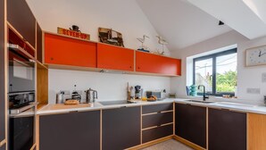 A modern kitchen with a large island, built-in appliances, and a window providing natural light. - 2 Bed in Rye (oc-s43273) (Rye Harbour)