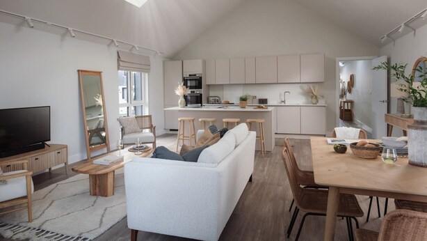 A modern living space with a kitchen, dining area, and a TV. - 2 Bed in Padstow (oc-b623759) (Padstow)
