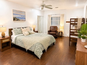 A bedroom with a bed, a chair, a desk, a ceiling fan, and a window with curtains. - The Primrose Coastal Retreat •Private Heated Pool • Near Anna Maria Island (Bradenton)
