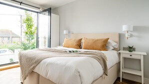 Una camera da letto moderna con un letto grande, due lampade da comodino, un tavolino e vista sull'esterno.