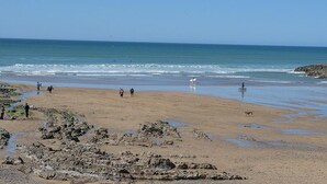 Una spiaggia con terreno roccioso e una vista libera sull'oceano.