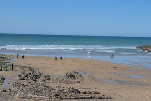 Ein Strand mit felsigem Gelände und freiem Blick auf den Ozean.