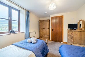 A bedroom with two beds, a wooden wardrobe, a television, and a window with a view. - 5 Bed in Grizebeck (oc-b34029) (Kirkby Ireleth)