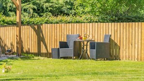 An outdoor seating area with a wooden fence, a table, and two chairs. - 1 Bed in Dunblane (oc-j36313) (Bannockburn)
