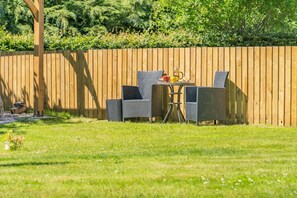 An outdoor seating area with a wooden fence, a table, and two chairs. - 1 Bed in Dunblane (oc-j36313) (Bannockburn)