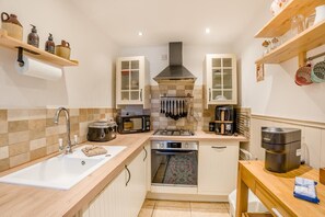 A compact kitchen with a sink, stove, microwave, and various utensils. - 1 Bed in Dunblane (oc-j36313) (Bannockburn)