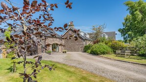 A stone house with a gravel driveway and a bench in the yard. - 1 Bed in Dunblane (oc-j36313) (Bannockburn)