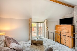 A bedroom with a bed, a wooden dresser, a television on the wall, and a window with curtains. - 2 Bed in Melton Mowbray (oc-h45352) (Hose)