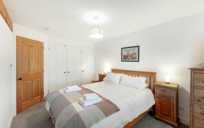 A bedroom with a bed, a wooden wardrobe, a nightstand, and a wall-mounted picture. - 3 Bed in Coniston (oc-lr149) (Coniston)