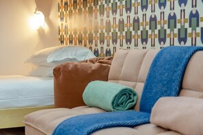 A hotel room with a bed, a sofa, and a patterned wall. - 4 Bed in Mawgan Porth (oc-s45397) (Mawgan Porth)