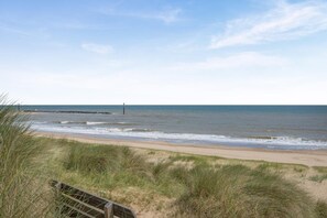 A beach with a sandy shore, grassy dunes, and a calm sea. - 1 Bed in Eccles-on-Sea (oc-w45218) (Lessingham)